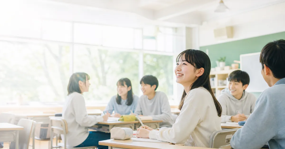 教室で笑顔を見せる中高生の写真（まなぶてらす学校ガイドのイメージ）