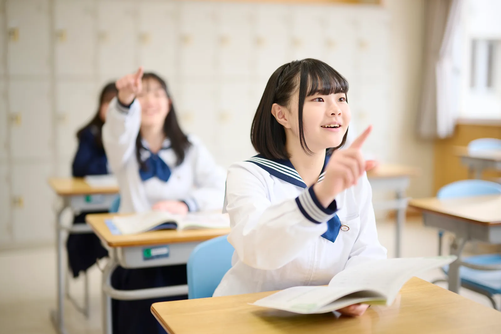相模女子大学中学部・高等部の授業の様子。教科書を開いた生徒が手を挙げている