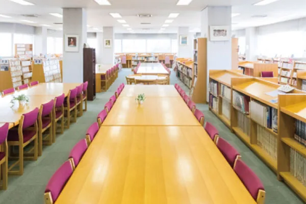 相模女子大学中学部・高等部の図書室。長机と椅子が並び、奥に書架が並んでいる