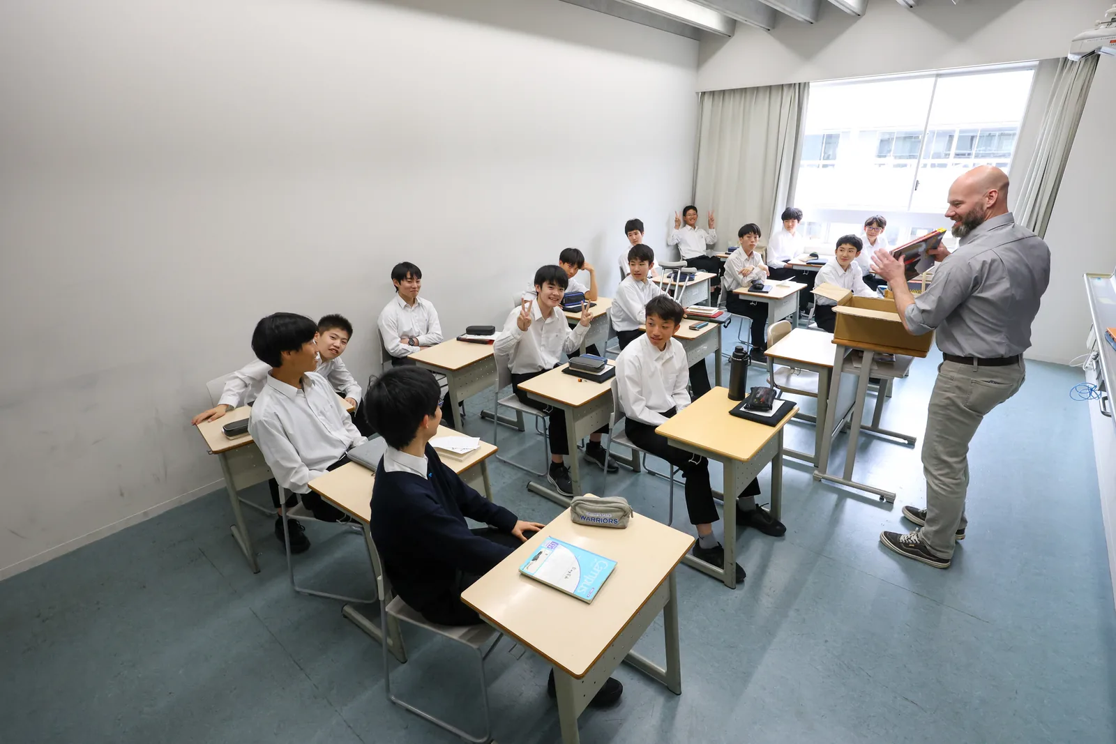 東京都市大学付属中学校・高等学校の英語の授業。教員が教室の前で話し、生徒が机に向かっている