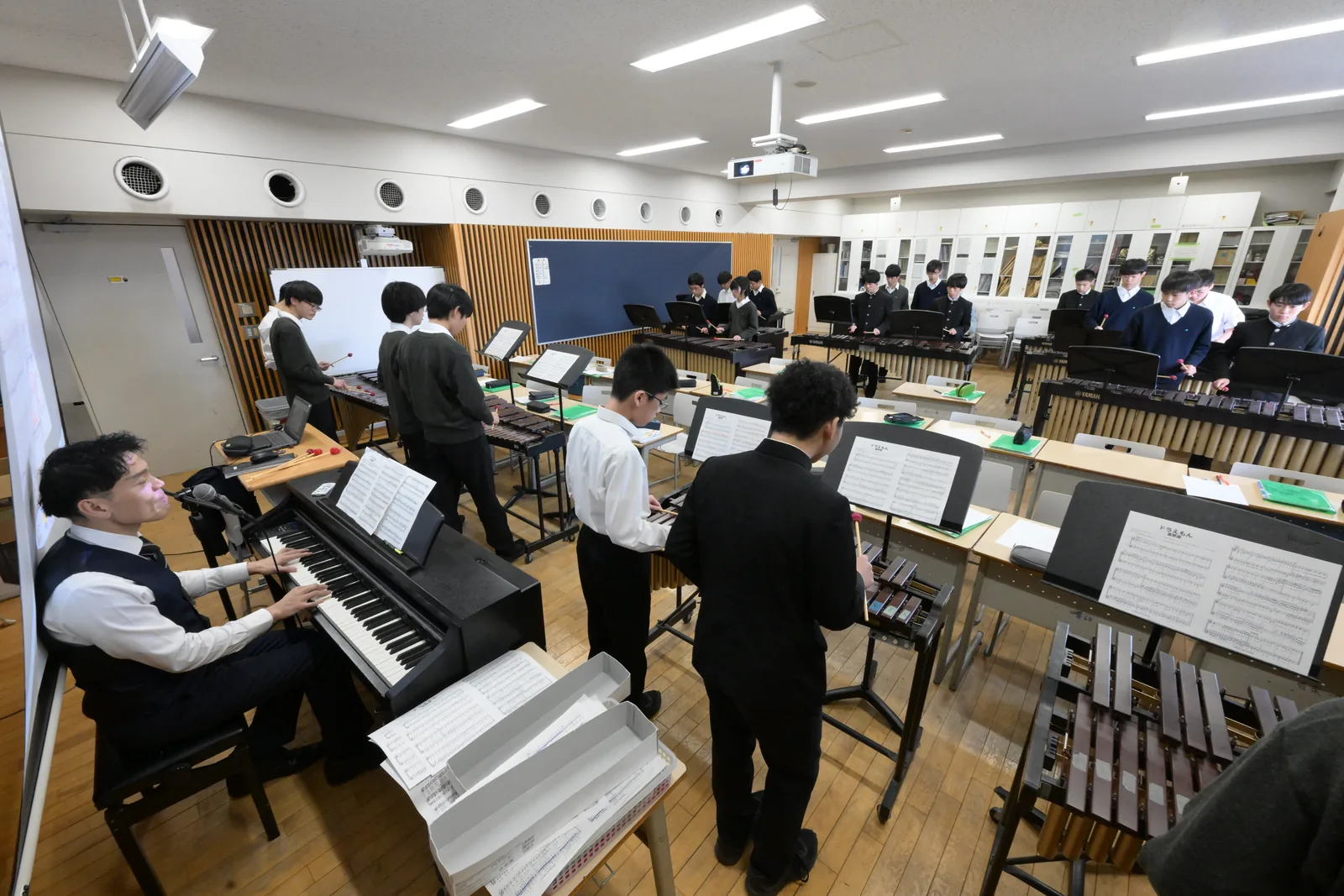 東京都市大学付属中学校・高等学校の音楽の授業。音楽室で生徒が電子オルガンやピアノに向かっている